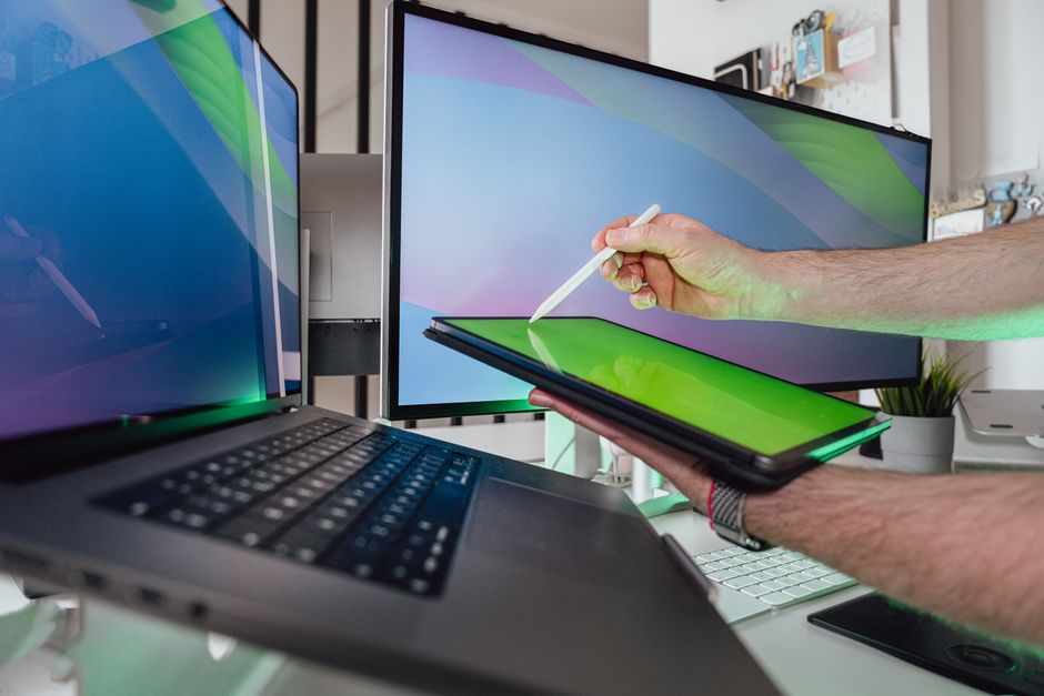 Osoba koristi stylus na tabletu u tehnološkom radnom prostoru